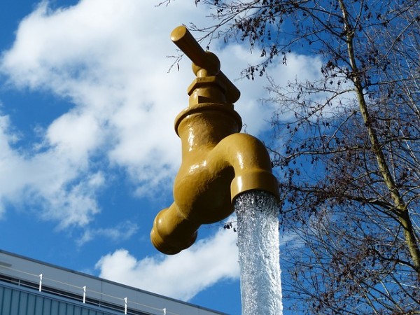 Foto zeigt einen Wasserhahn der in der Luft zu hängen scheint. Wasser fließt heraus.